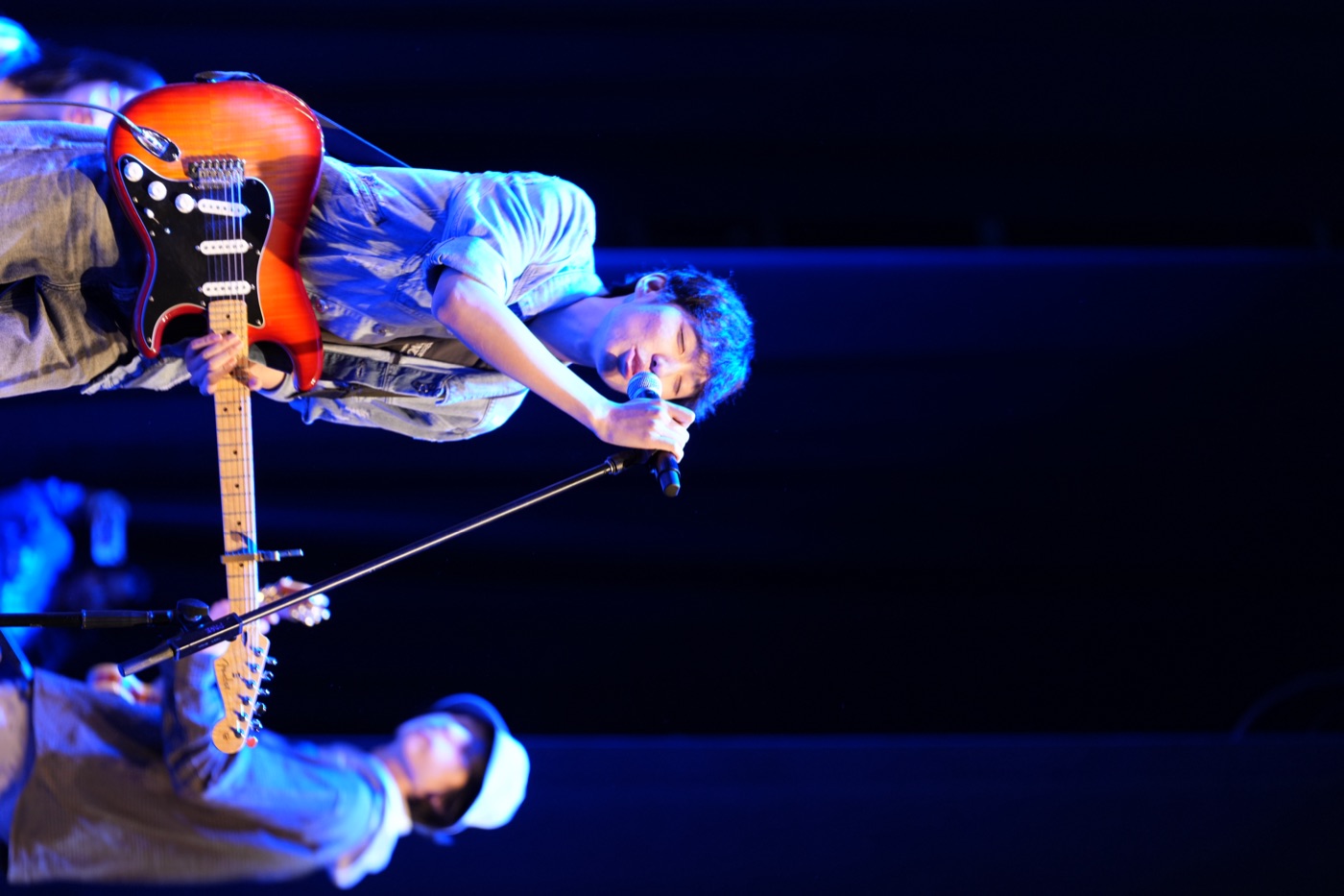 Guitarist performing on blue stage